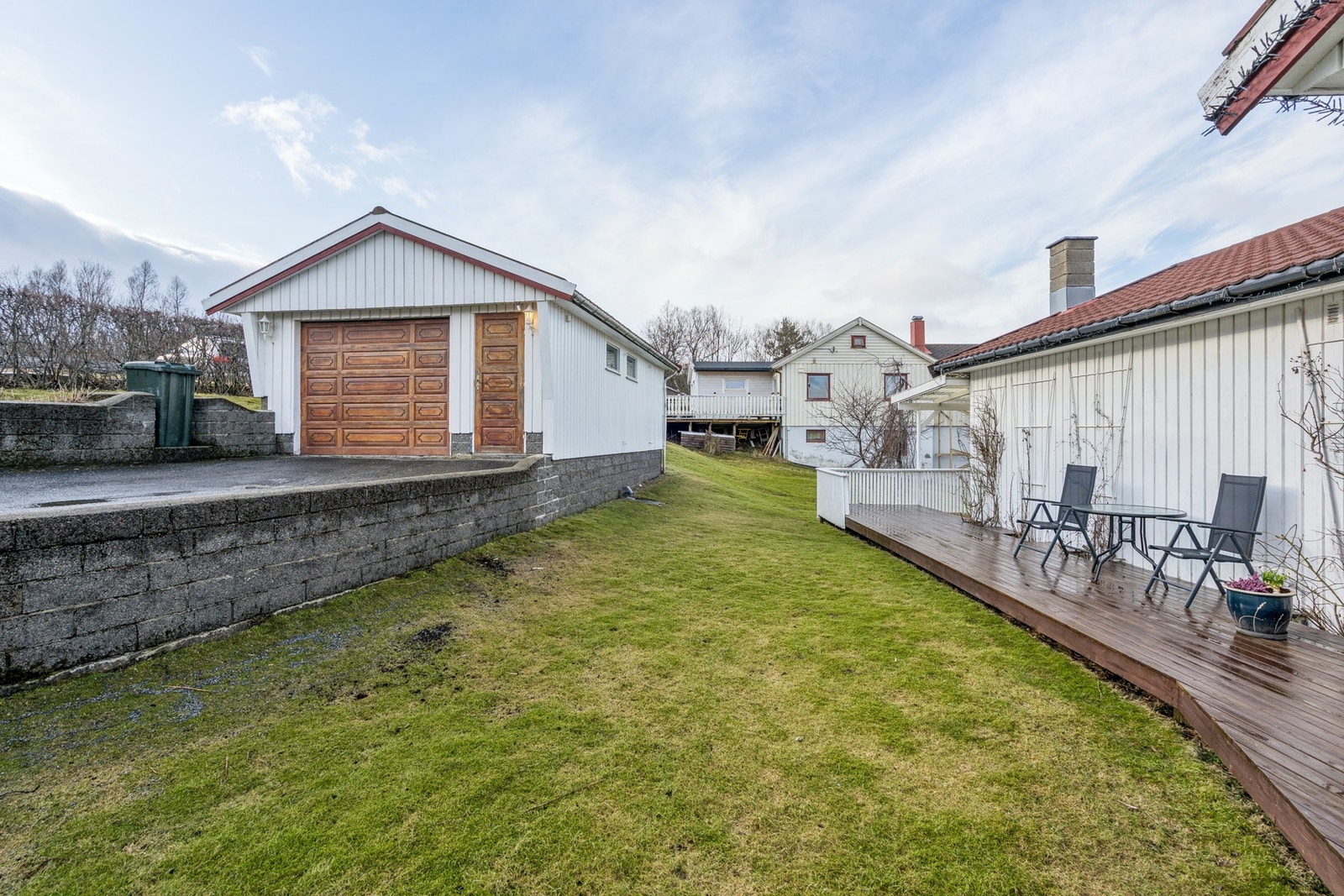 Eiendommen har en frittstående garasje på 34 m² med leddport og en integrert vedbod. Galleribilde