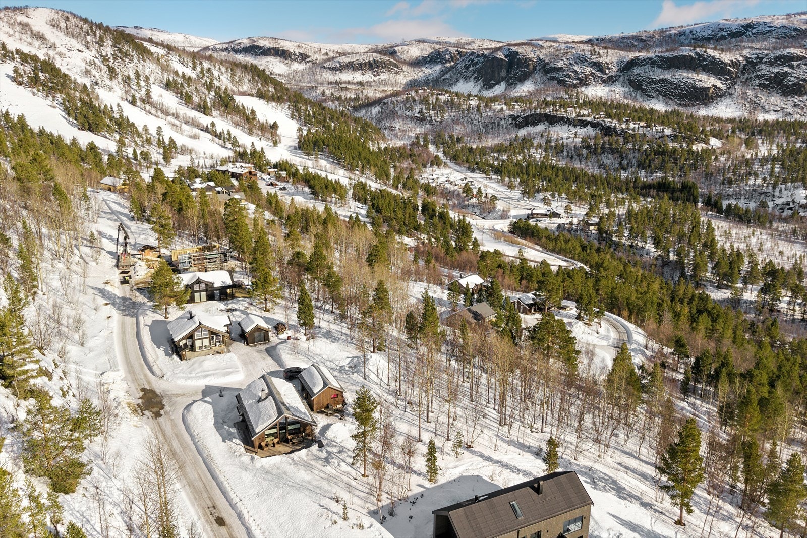 Tomten har skrånende terreng og ligger i naturskjønne omgivelser, med utsyn mot omkringliggende skog- og fjellområder. Galleribilde