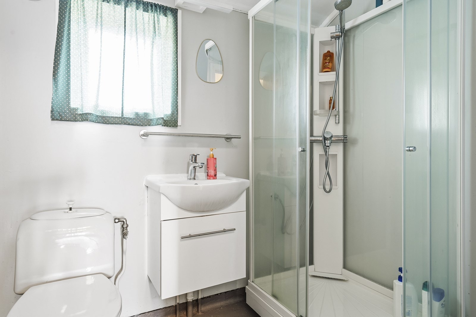 Badet er utstyrt med innredning med nedfelt servant, toalett og dusjkabinett. Det har en elektrisk styrt vifte som sørger for ventilasjon, og rommet varmes opp med panelovn for en behagelig temperatur året rundt. Galleribilde