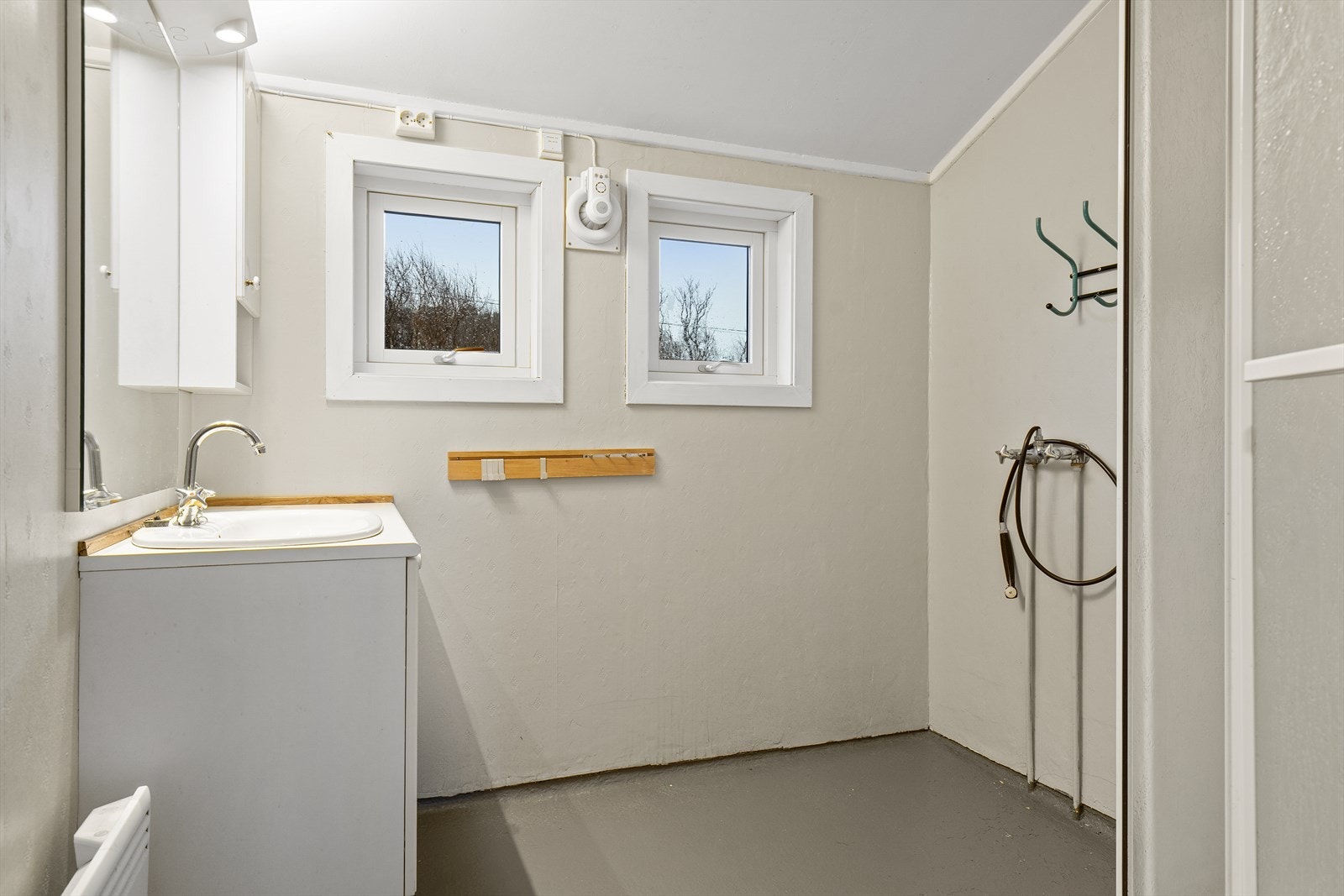 Badet er fra byggeåret 1959 og har våtromstapet på veggene og malt tak. Rommet er innredet med servantseksjon og dusjkabinett. Galleribilde