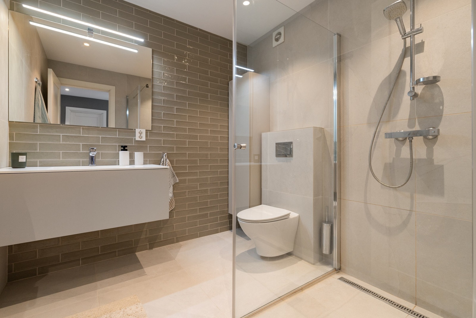 Lekkert bad med spa-følelse fra 2019/2020. Farge- og materialvalg gir et eksklusivt og moderne preg, samtidig som det er et funksjonelt familiebad Galleribilde