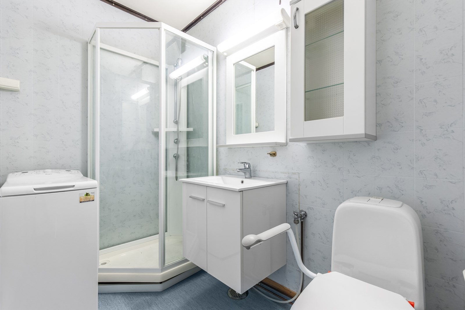 Badet er utstyrt med dusjkabinett, servant og toalett. Galleribilde