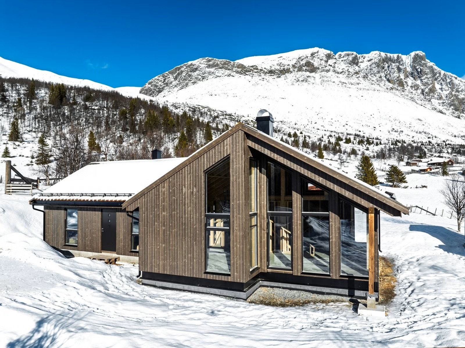 Hytten har moderne arkitektur og store vinduer fra gulv og helt opp til mønet som rammer inn den vakre utsikten Galleribilde