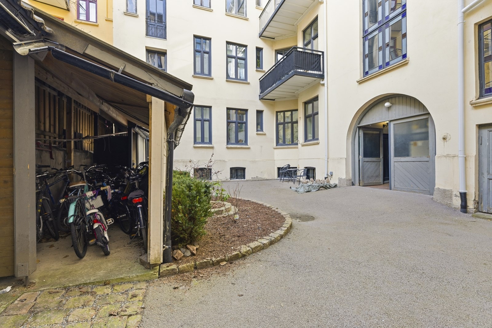 Opparbeidet bakgård med blant annet sykkelparkering og søppelskur Galleribilde