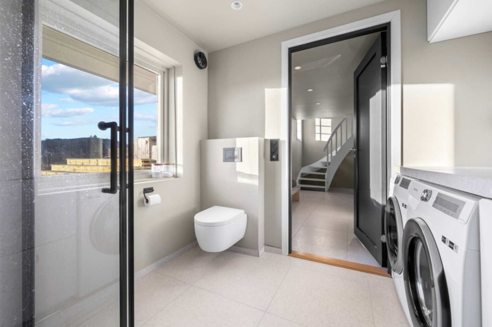 Badet er innredet med dusj, vegghengt toalett, vask og opplegg til vaskemaskin. Galleribilde