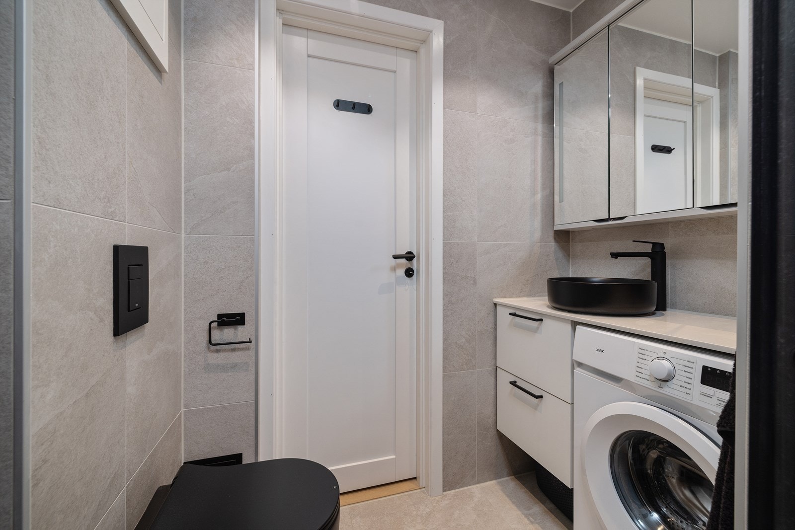 Innredningen består av en toppmontert servant, speilskap med belysning og et vegghengt toalett. Galleribilde