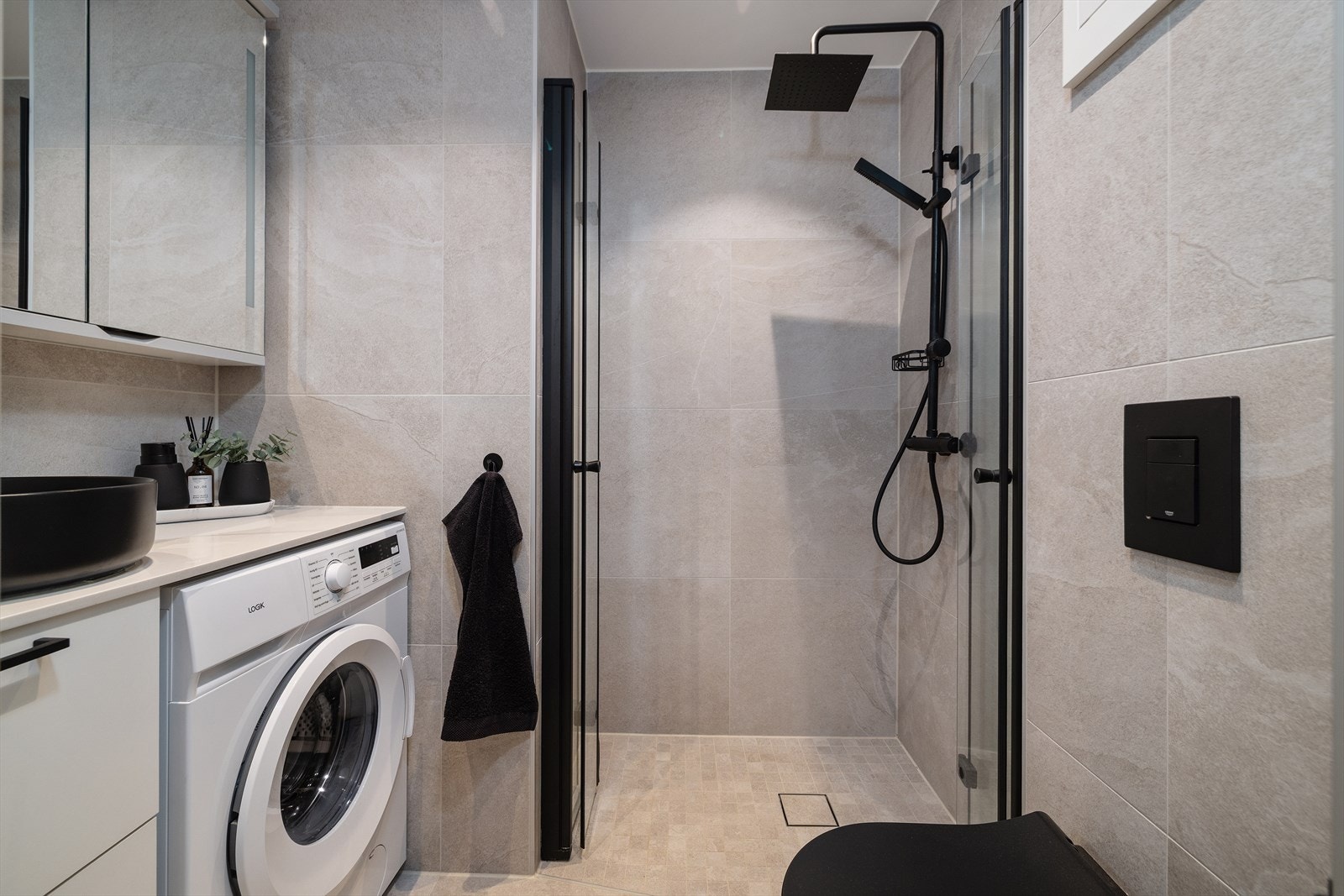 Her er det en praktisk dusjnisje med glassdør, samt opplegg for vaskemaskin. Rommet har mekanisk avtrekk. Galleribilde