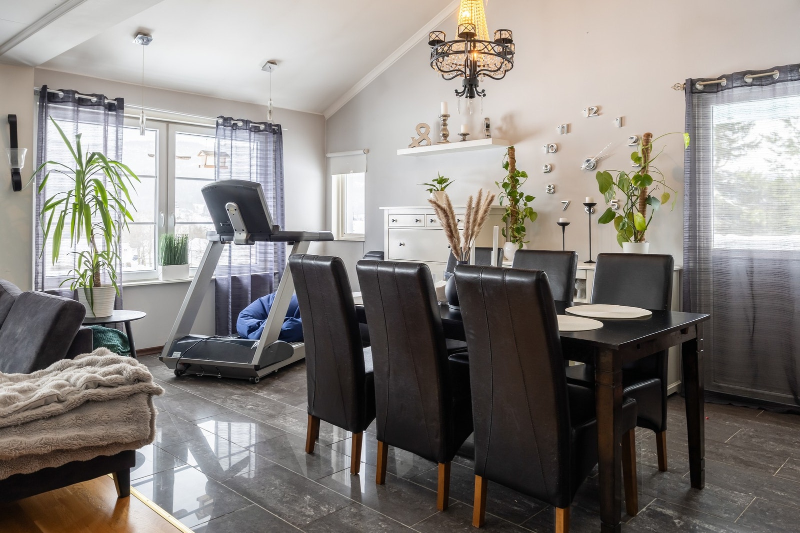 Lys og innbydende spisestue med store vinduer, perfekt for hyggelige familiestunder. Galleribilde