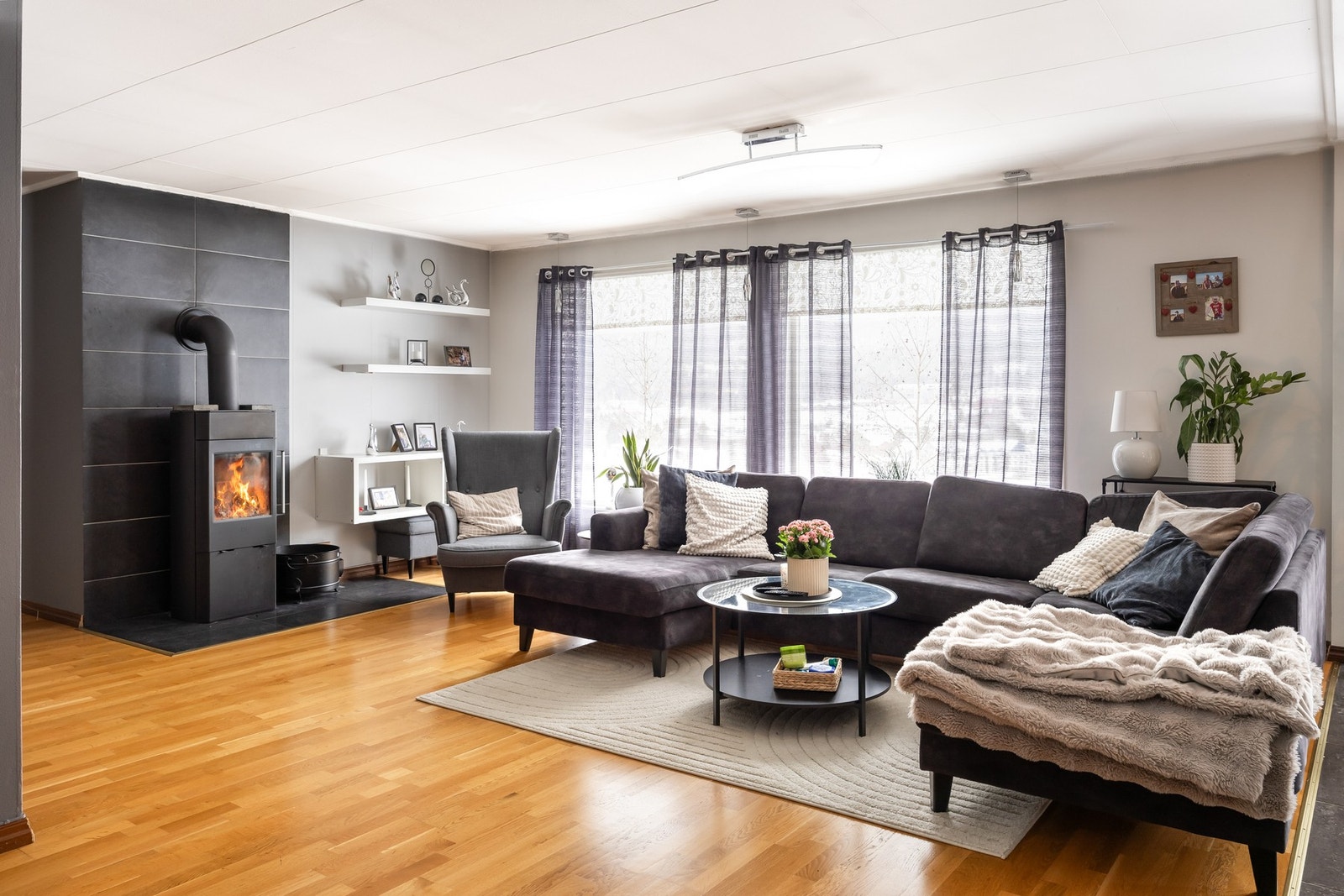 Romslig stue med store vindusflater og peis. Galleribilde