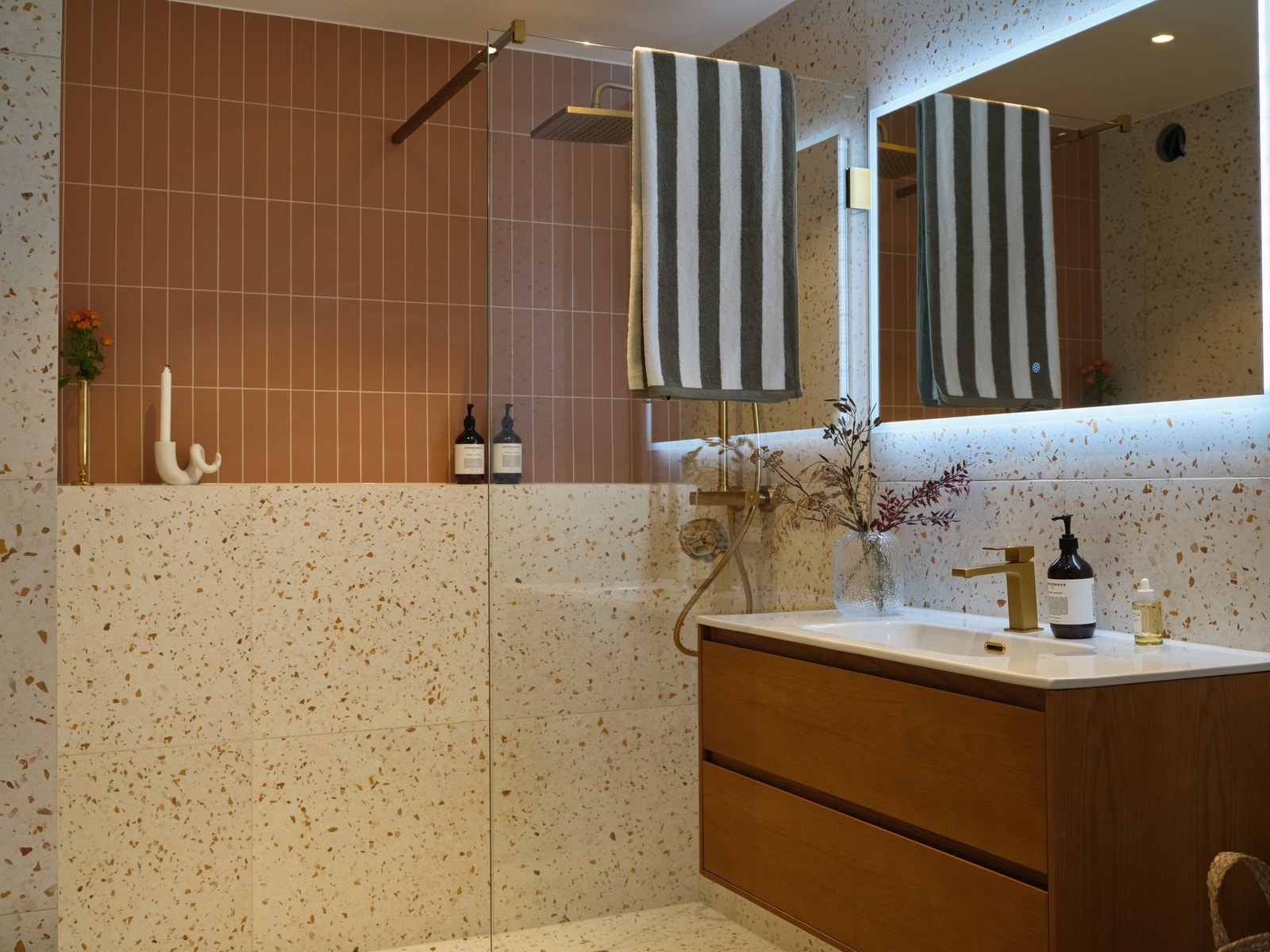 Stilren servant med underskap og glatte fronter, samt speil med integrert belysning som kombinerer funksjonalitet og design. Galleribilde