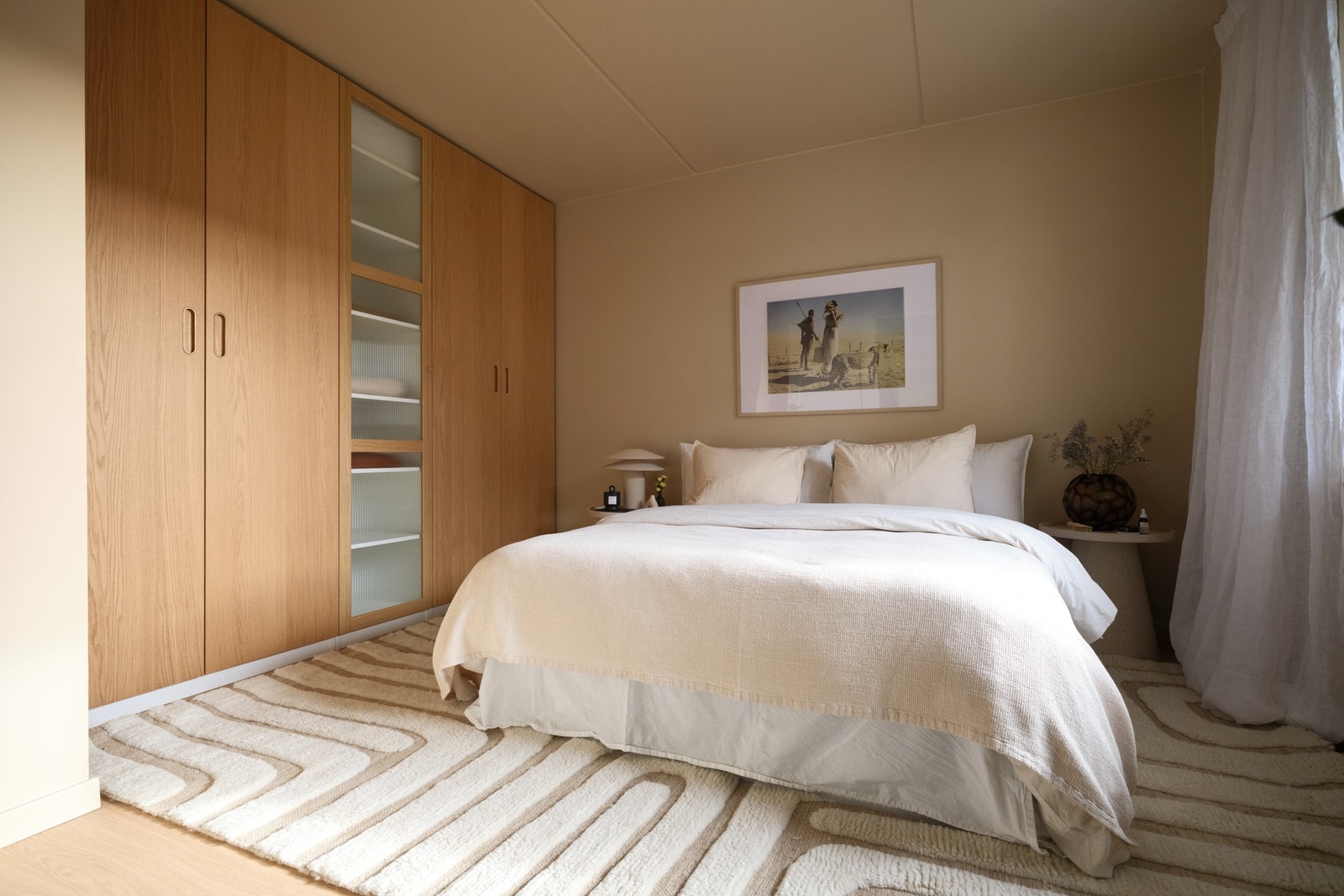 Integrert garderobeløsning med glatte fronter og detaljer i tre tilfører rommet både funksjonalitet og et varmt, eksklusivt uttrykk. Galleribilde