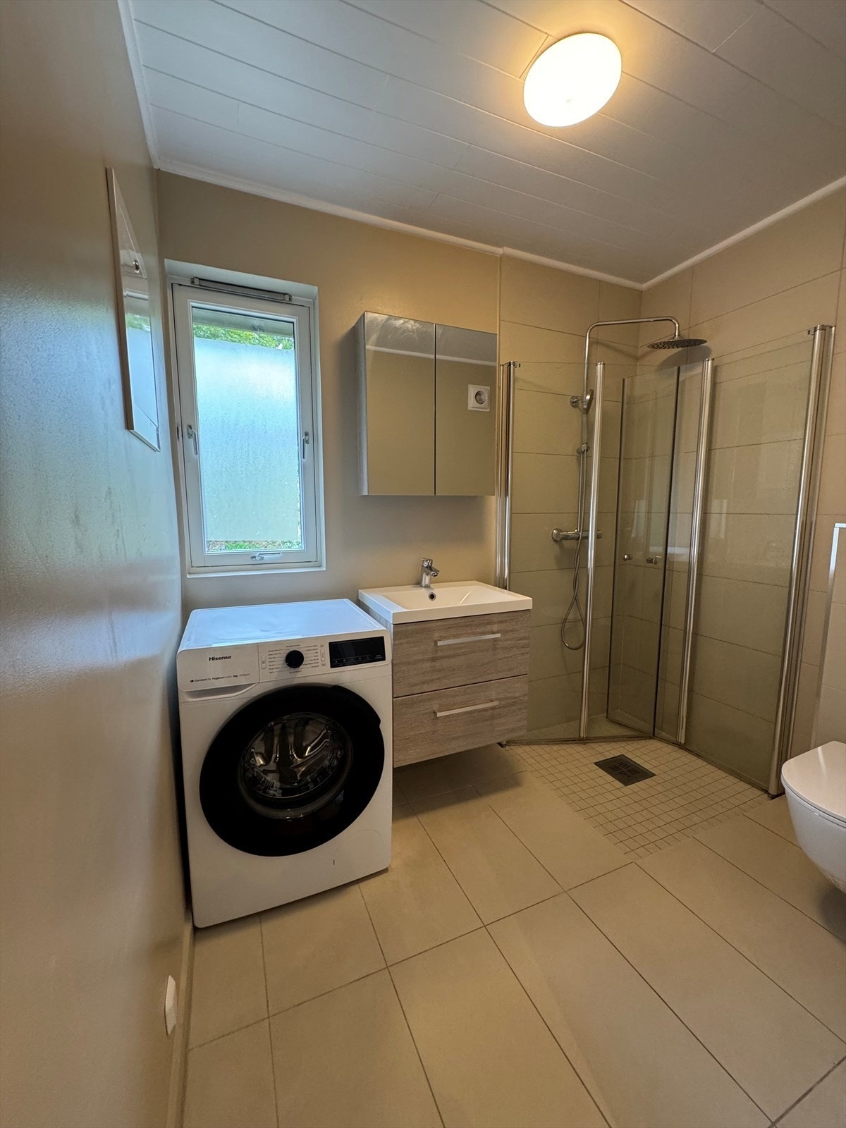 Flislagt baderom med opplegg for vaskemaskin. Galleribilde