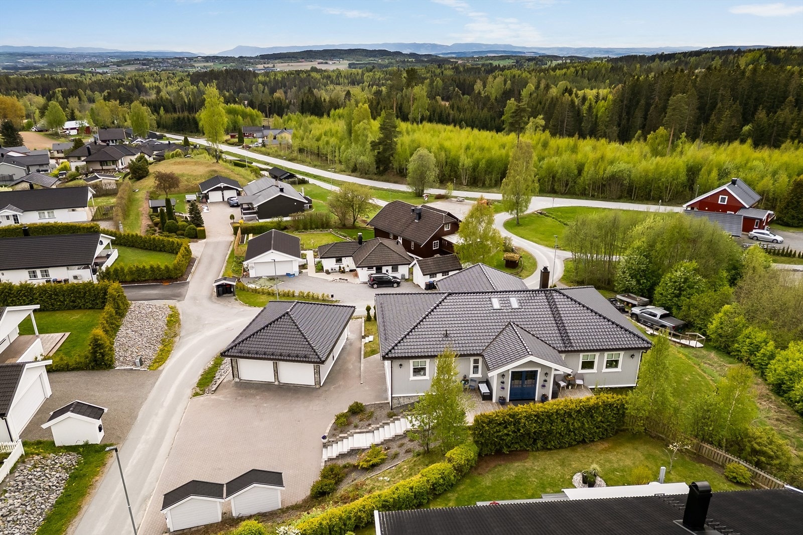 Eiendommen er meget pent opparbeidet med belegningsstein i gårdsplasse, plen, beplantning, prydbusker m.m. Galleribilde