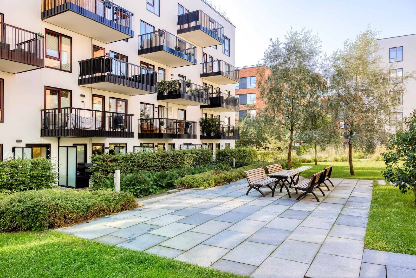 Like utenfor leiligheten er det en liten sittegruppe og grønn plen. Galleribilde