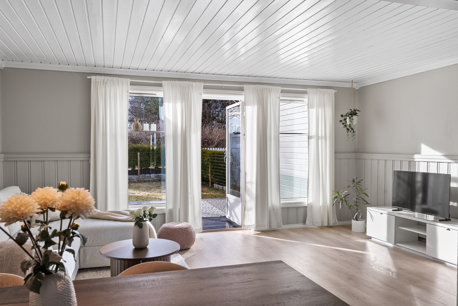 Store vindusflater gir utsyn mot hageområde. Galleribilde