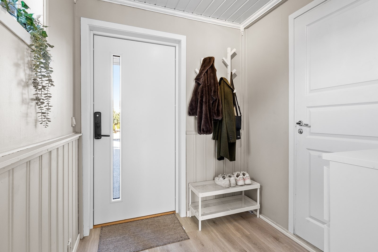 Entréen har laminatgulv fra 2025, som gir et slitesterkt og moderne preg, samt tilgang til en romslig bod. Galleribilde