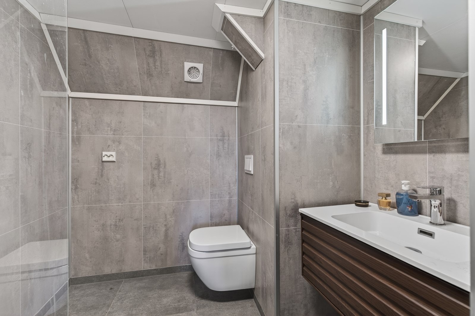 Badet i kjelleren har flislagt gulv med varmekabler og våtromsplater på veggene, i tillegg til dusjsonen og en praktisk baderomsinnredning. Galleribilde