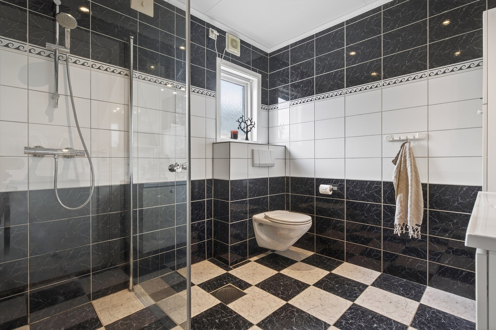 Hovedbadet er helfliset og tilbyr varmekabler, dusjhjørne, vegghengt toalett og stor servantinnredning Galleribilde