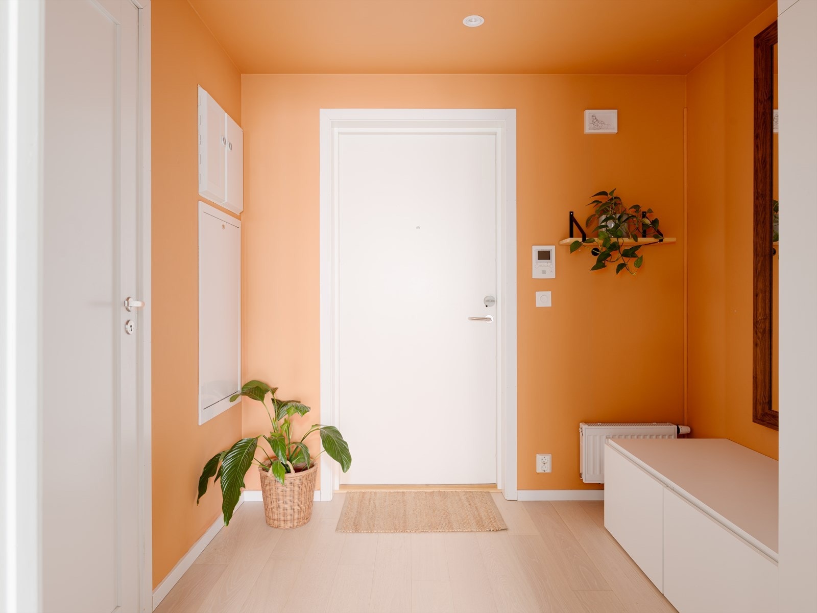 En oversiktlig og stemningsfull entré i varme, orange nyanser ønsker deg velkommen inn. Galleribilde