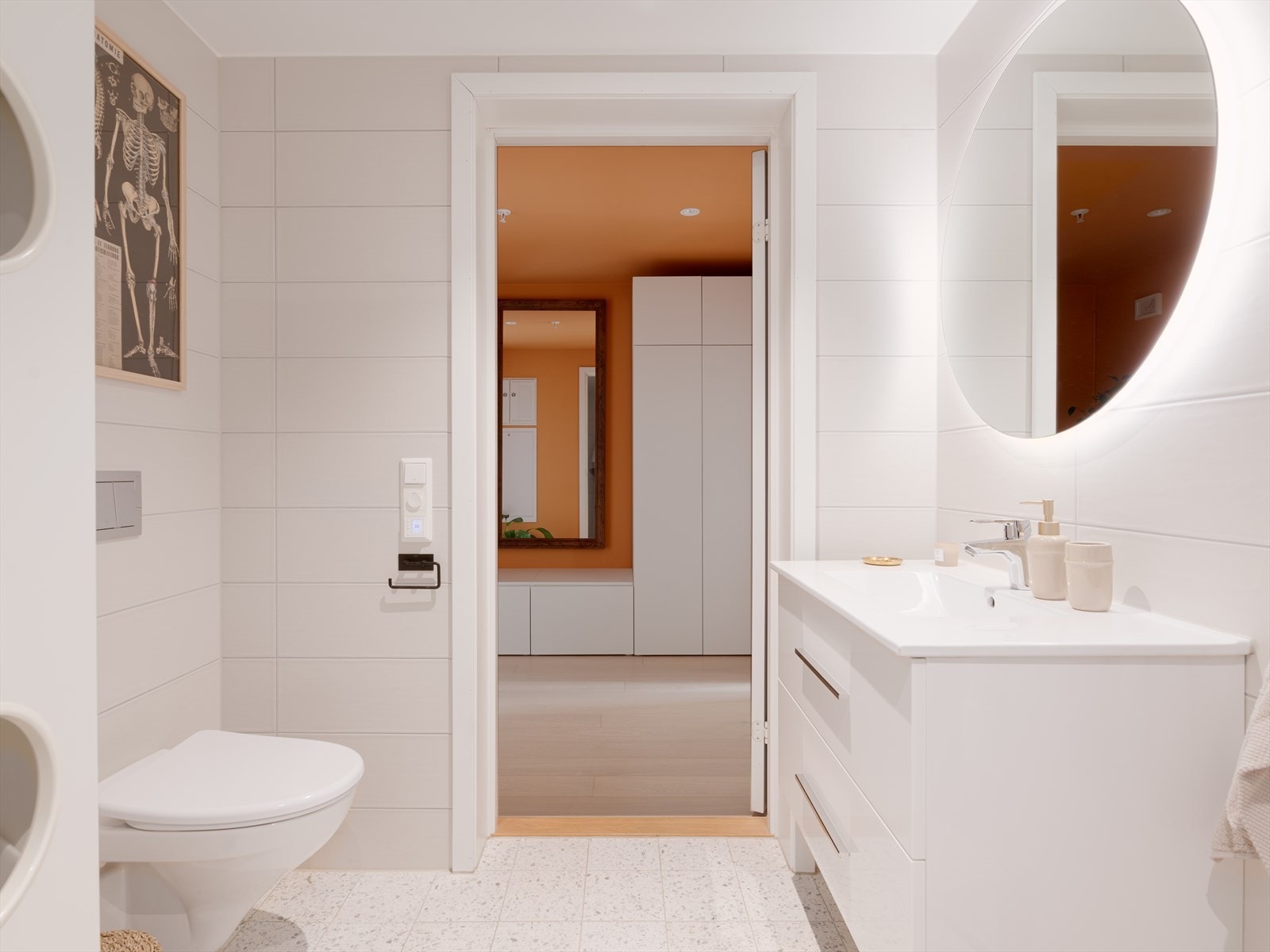 Innredningen består av heldekkende servant med underskap, speil med integrert belysning, veggmontert toalett, nedsenket dusj med glassdører og opplegg for vaskemaskin. Galleribilde