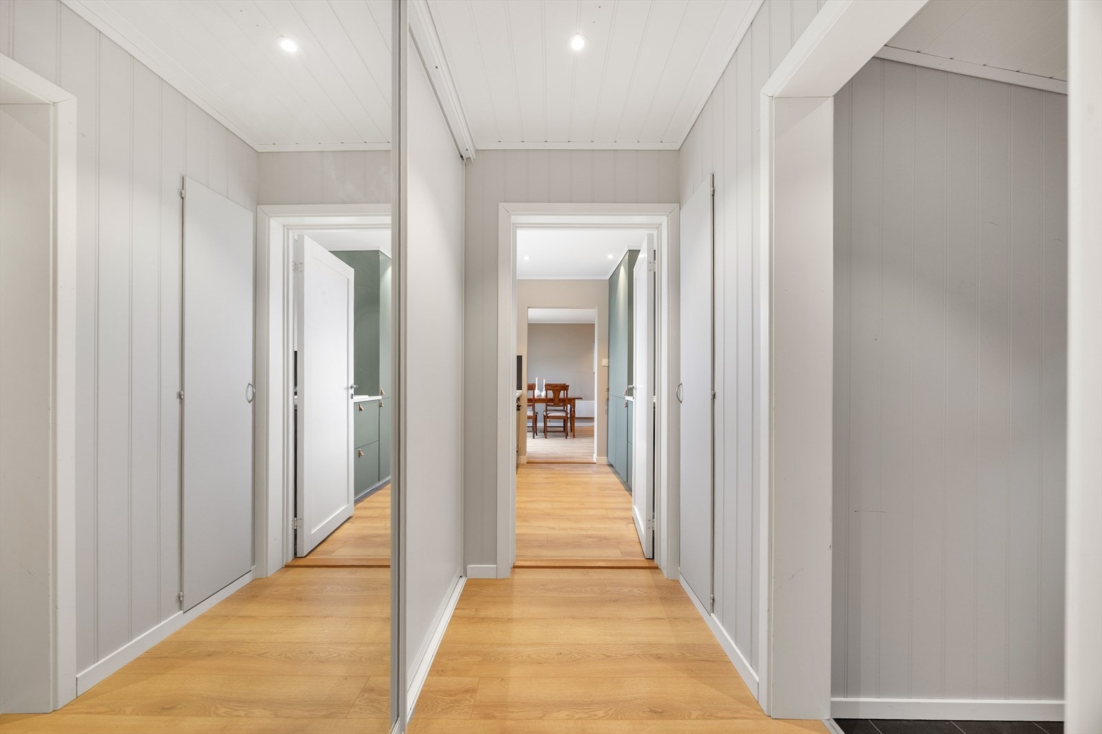 Fra mellomgangen og videre inn i boligen er det moderne laminat på gulvet og duse, harmoniske fargetoner. I mellomgangen er det godt med oppbevaringsplass i stor skyvedørsgarderobe samt i tilliggende kott. Galleribilde