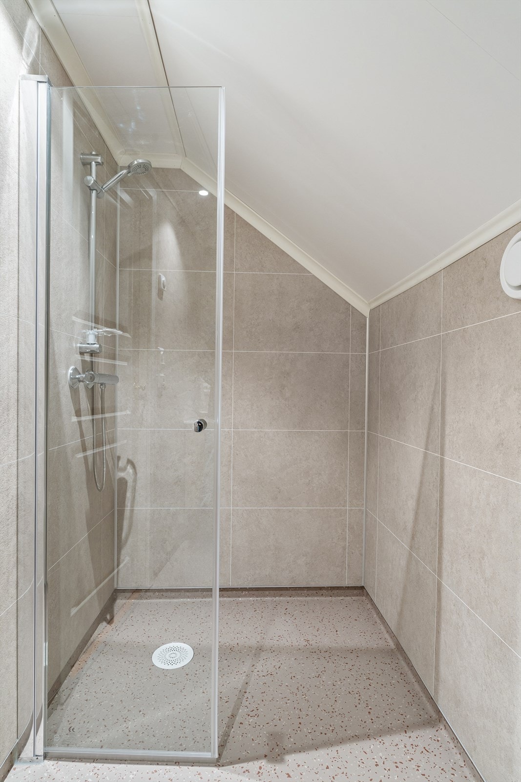 Lekkert bad med dusj, vegghengt toalett og vask i skuffeseksjon Galleribilde