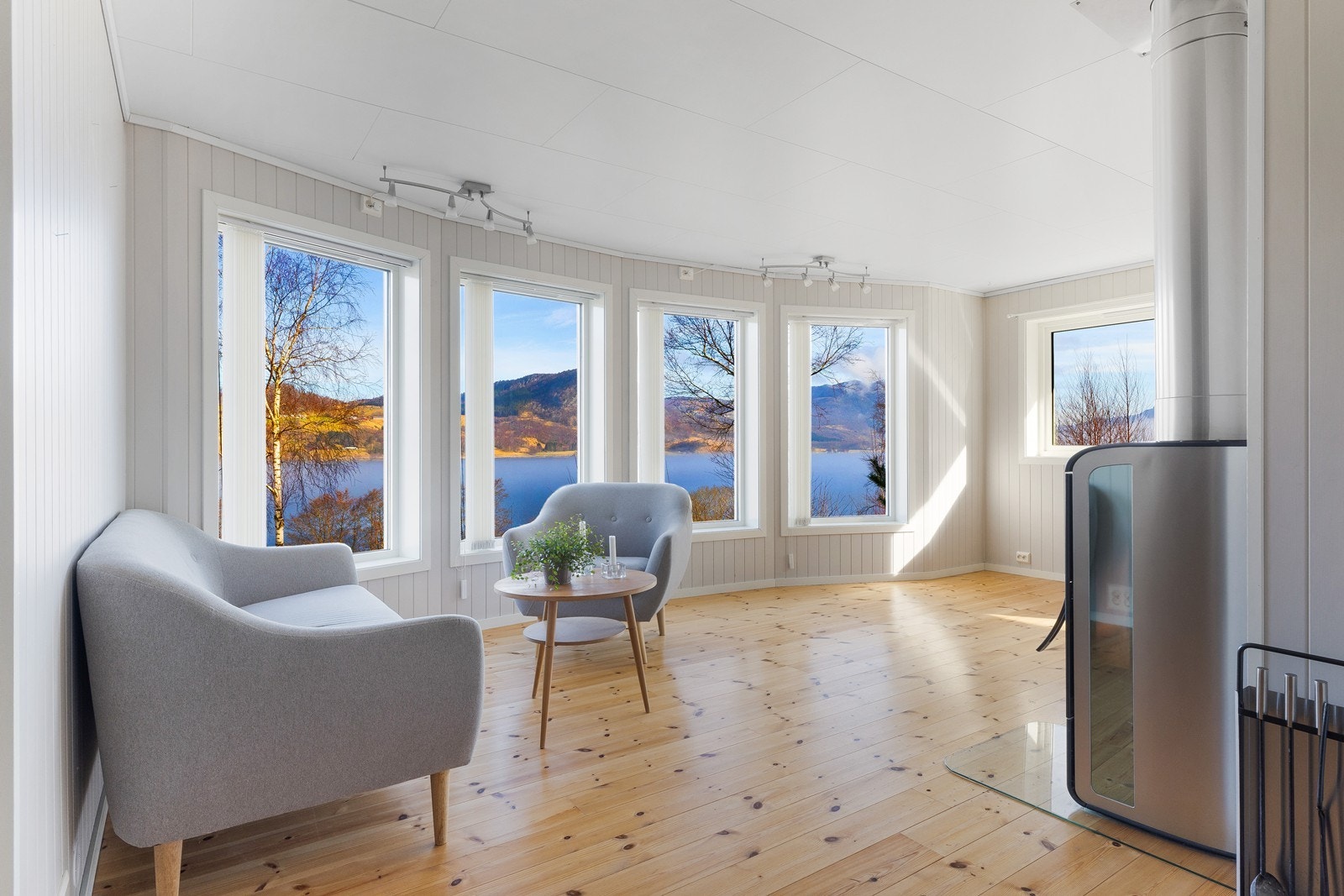 Lys og romslig stue med store vindusflater som slipper inn den nydelige utsikten Galleribilde