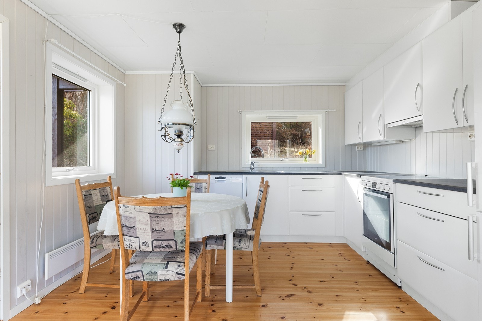 Kjøkkenet har innredning med hvite fronter og det er god skap- og benkeplass Galleribilde