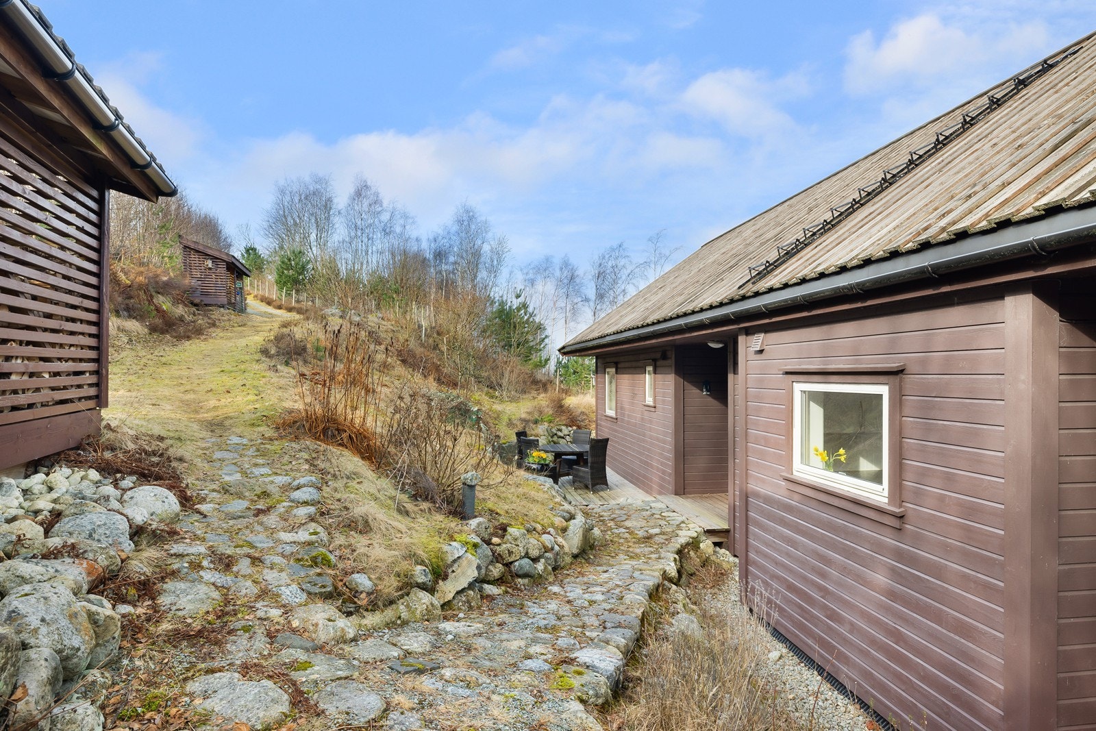 Eiendommen er pent opparbeidet med stier og beplantning. Man har også kjørevei helt frem til hytten med parkering på egen tomt. Galleribilde