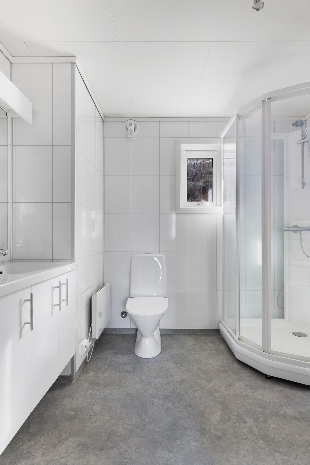 Romslig og lyst baderom med belegg på gulv og plater på vegg. Galleribilde