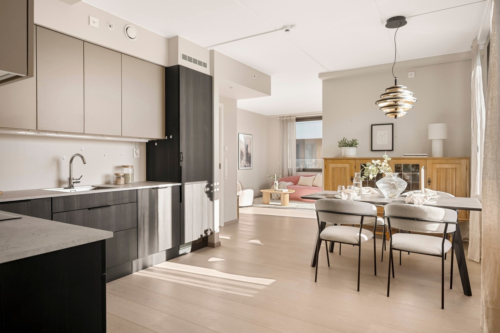 Åpen stue/kjøkken løsning med lyse overflater og moderne kontraster. Galleribilde