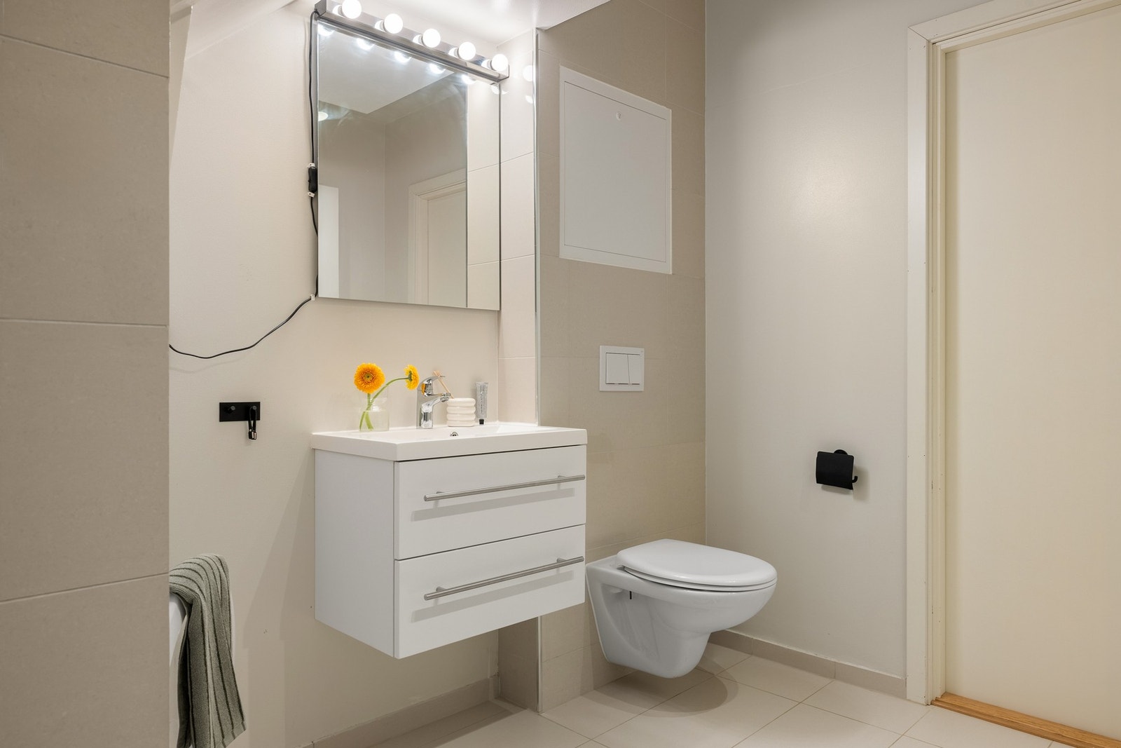 Badet er innredet med dusj med glassvegger, vegghengt toalett, baderomsinnredning og opplegg for vaskemaskin. Galleribilde