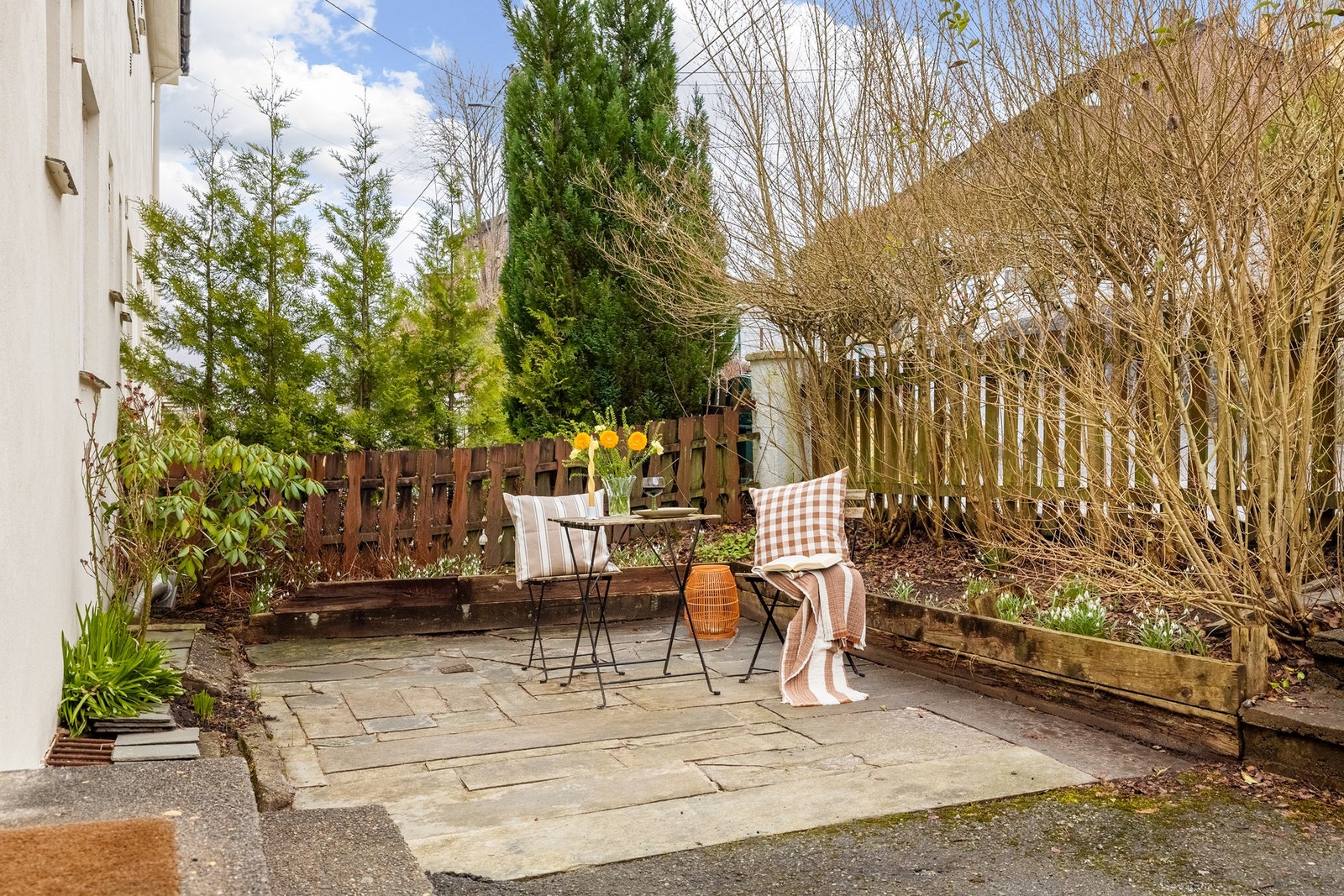 Selger opplyser om at fremsiden er solrik på sommerstid og godt skjermet til veien når buskene får vegetasjon og blader. Galleribilde