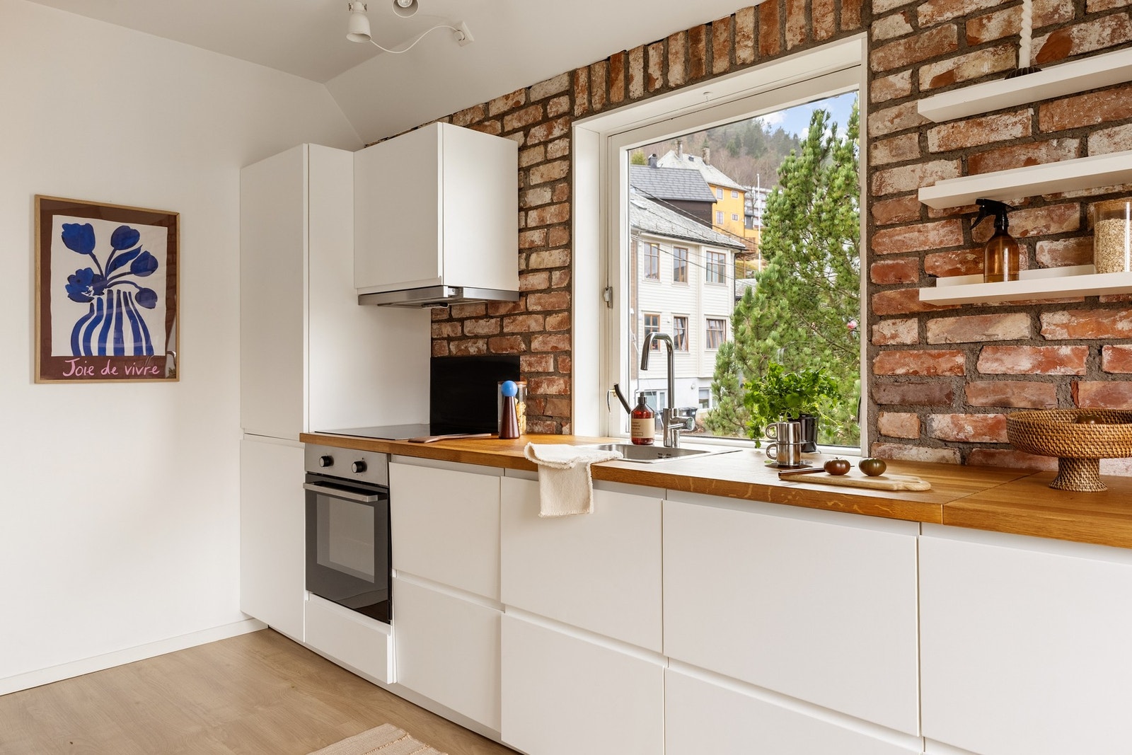 Kjøkkenet ligger i åpen løsning med stuen og har en lang benkeplate som gir gode arbeidsflater. Galleribilde