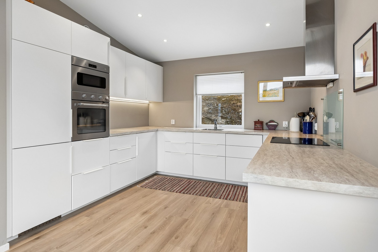 Stort og moderne kjøkken med slett innredning og integrerte hvitevarer. Galleribilde