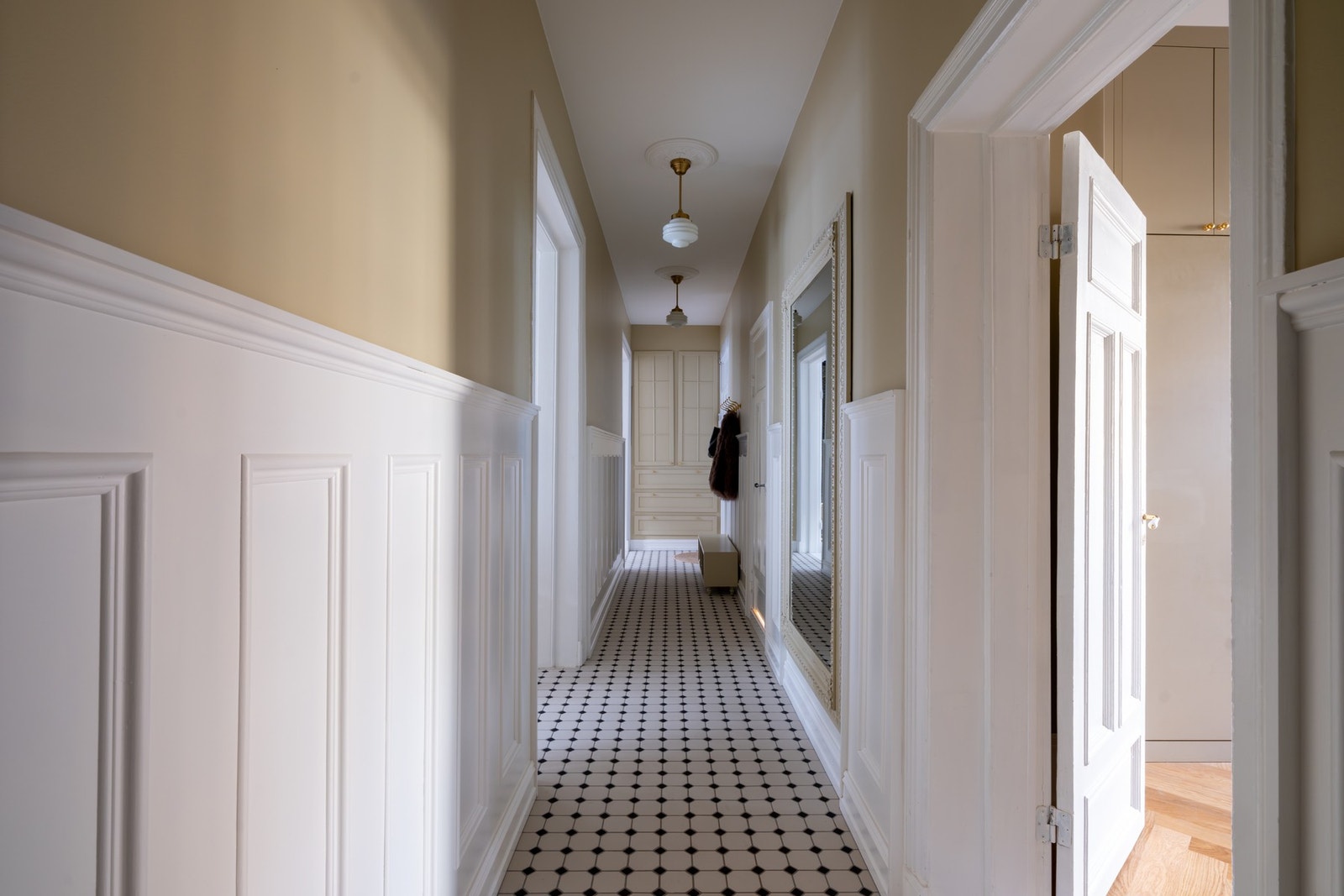 Romslig entré/gang med klassiske fliser og tidstypiske detaljer. Galleribilde