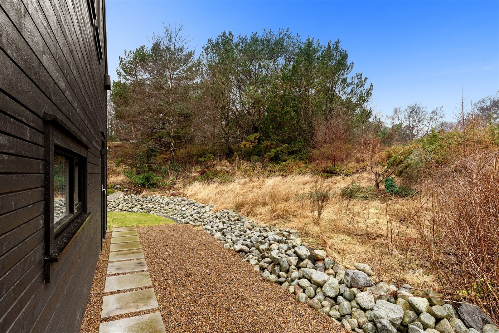 Grenser til friareal, med ferdig opparbeidet gårdsrom, gressplen og pyntestein. Galleribilde