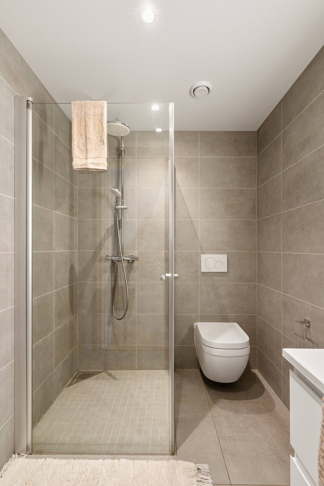 Helfliset bad i 1. etasje med spotter i tak og hvit baderoms innredning. Galleribilde