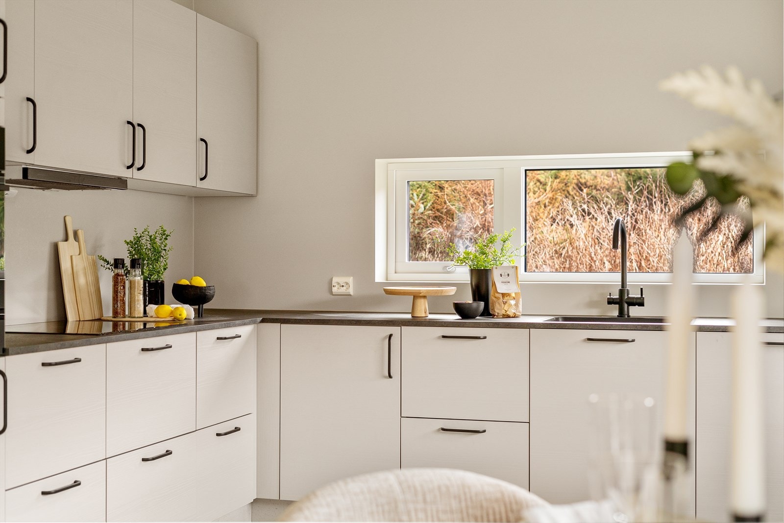 Tidløst kjøkken med fronter i grå toner og mørk benkeplate. Kjøkkenet er fra Aubo, med inkluderte hvitevarer fra AEG. Galleribilde