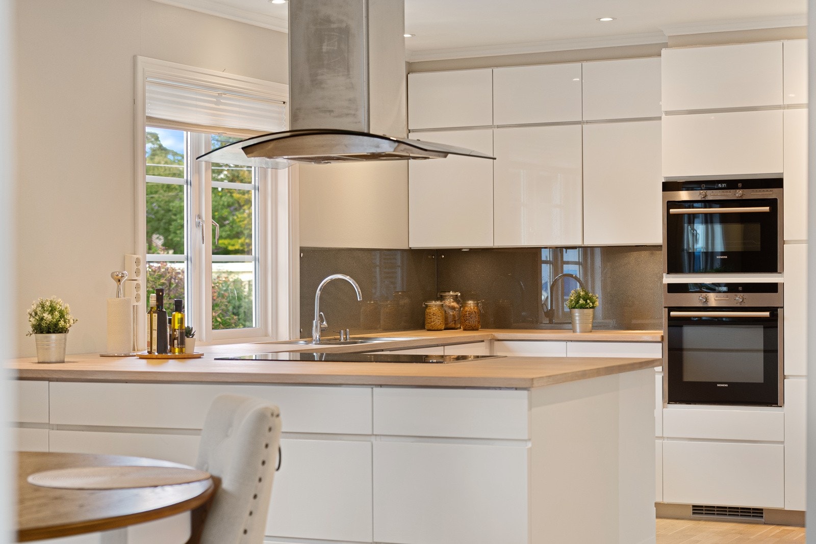 Kjøkkenet er stilrent og moderne, med minimalistiske, slette fronter og en heltre benkeplate. Galleribilde