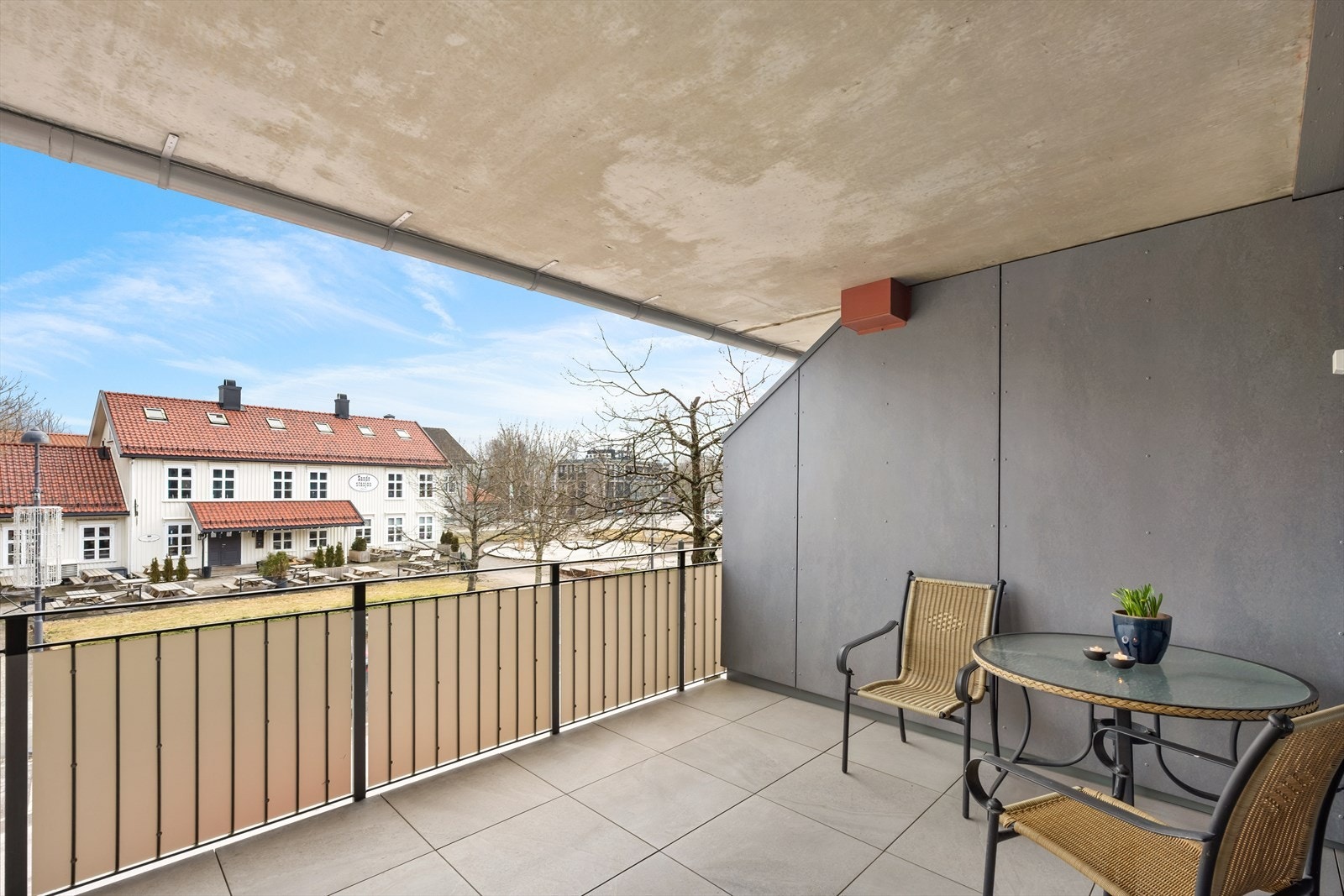 Terrassen har gulv av store betongheller og et solid rekkverk i metall. Galleribilde