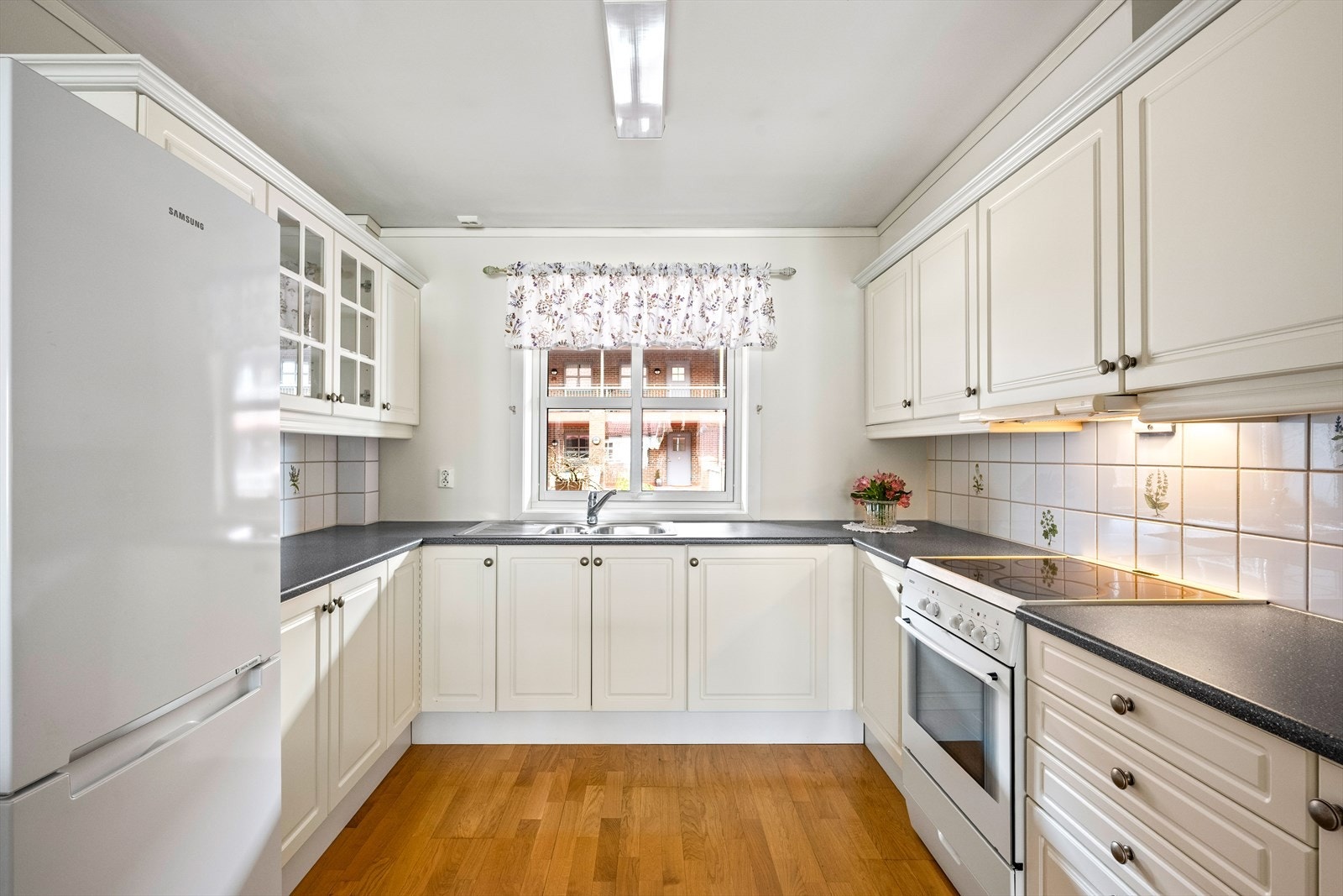 Rommet er utstyrt med frittstående hvitevarer, inkludert kjøl/fryseskap og komfyr med komfyrvakt. Galleribilde