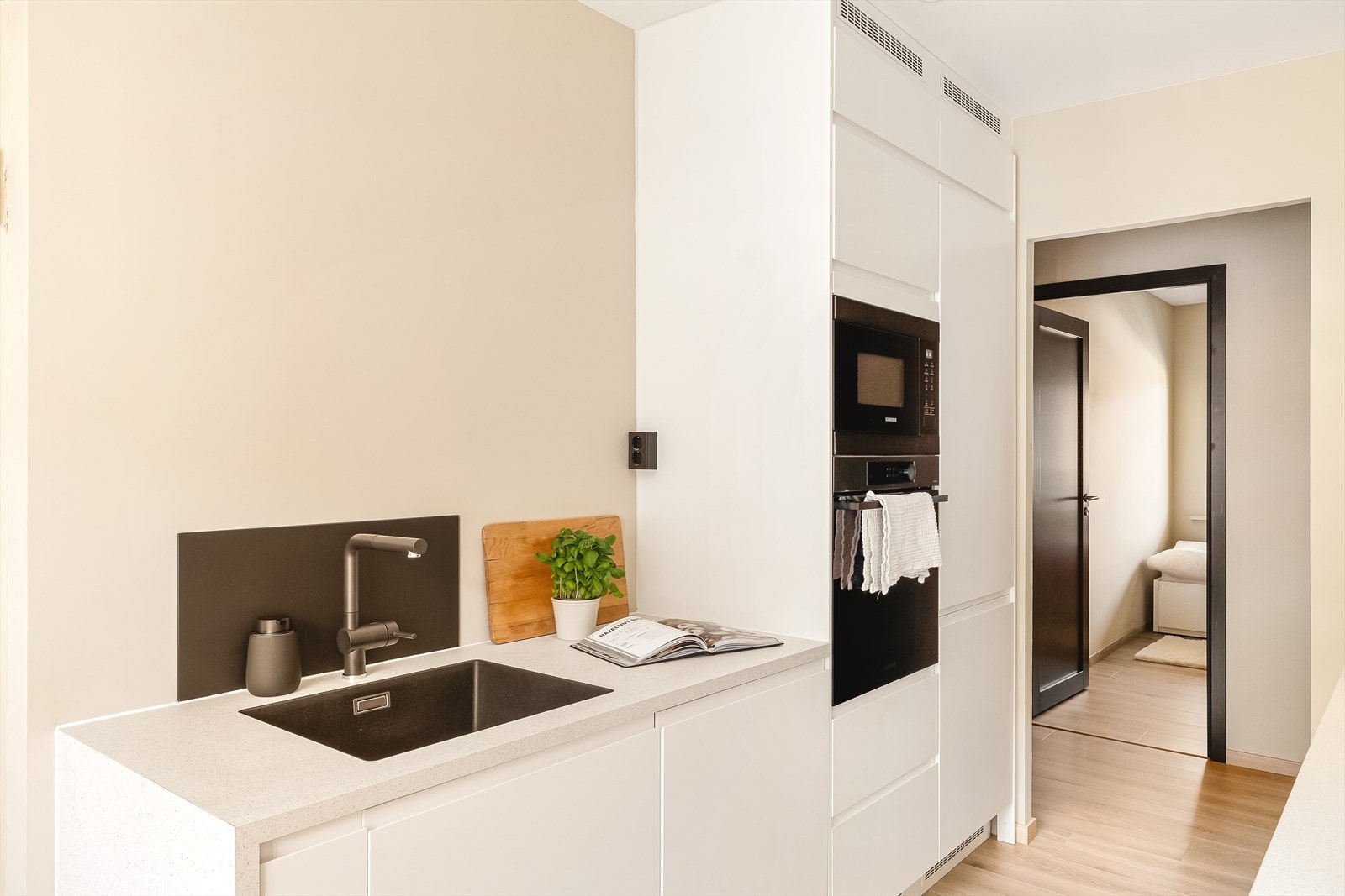 Kjøkkenet er utstyrt med ventilator og integrerte hvitevarer, inkludert stekeovn, induksjonstopp (80 cm), oppvaskmaskin, mikrobølgeovn og kjøle-/fryseskap. For økt trygghet er det installert både komfyrvakt og Aquastop. Galleribilde