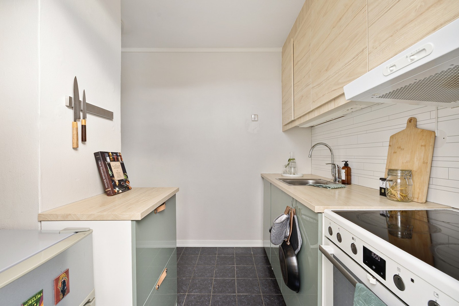 Kjøkkenet ble oppgradert i 2019 og framstår i god stand. Det er er flis på gulv, malt glassfiberstrie på vegger med våtromsplate mellom benkeplate og overskap og malt betonghimling. Galleribilde