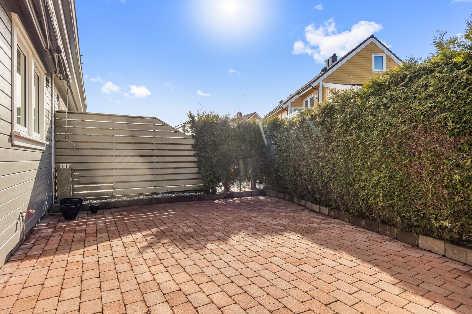 Steinbelagt uteplass ved inngangspartiet Galleribilde