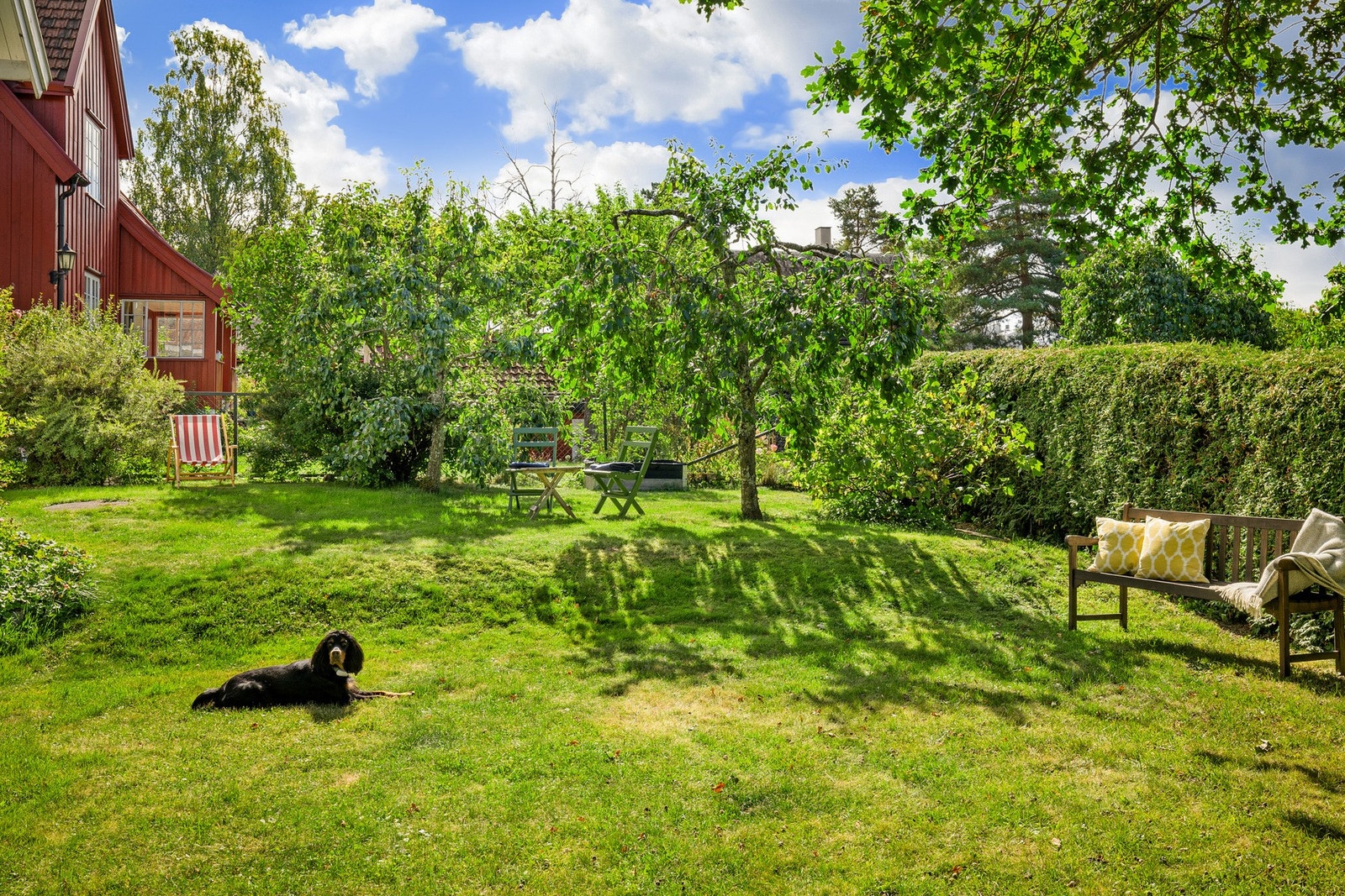 Hagen er pent opparbeidet med en romslig gressplen, innrammet av variert beplantning som busker, trær og hekker som gir et skjermet uteområde. Galleribilde