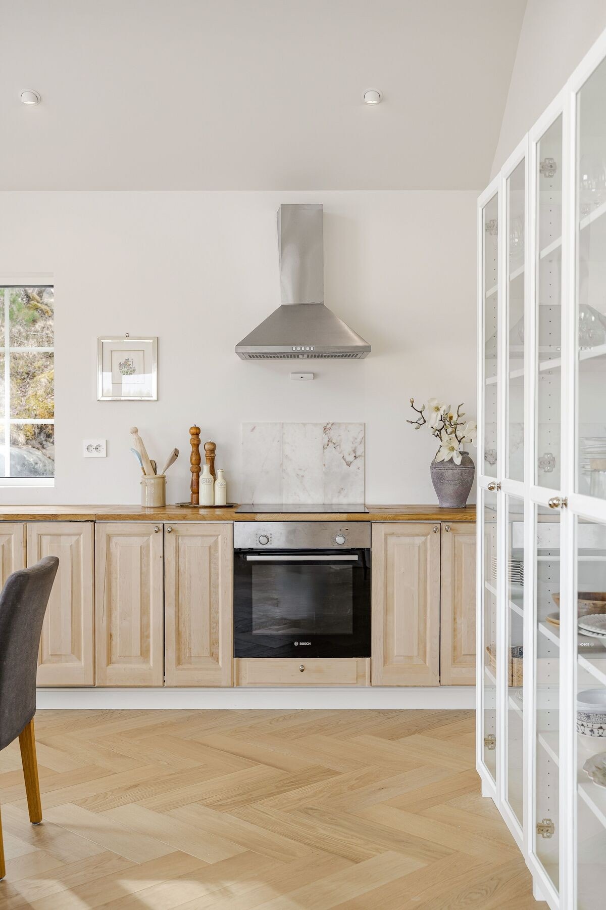 Innredningen med shaker-fronter i ubehandlet heltre bjørk kombineres med kromfargede, klassiske knotter, som gir et harmonisk og elegant uttrykk. Galleribilde