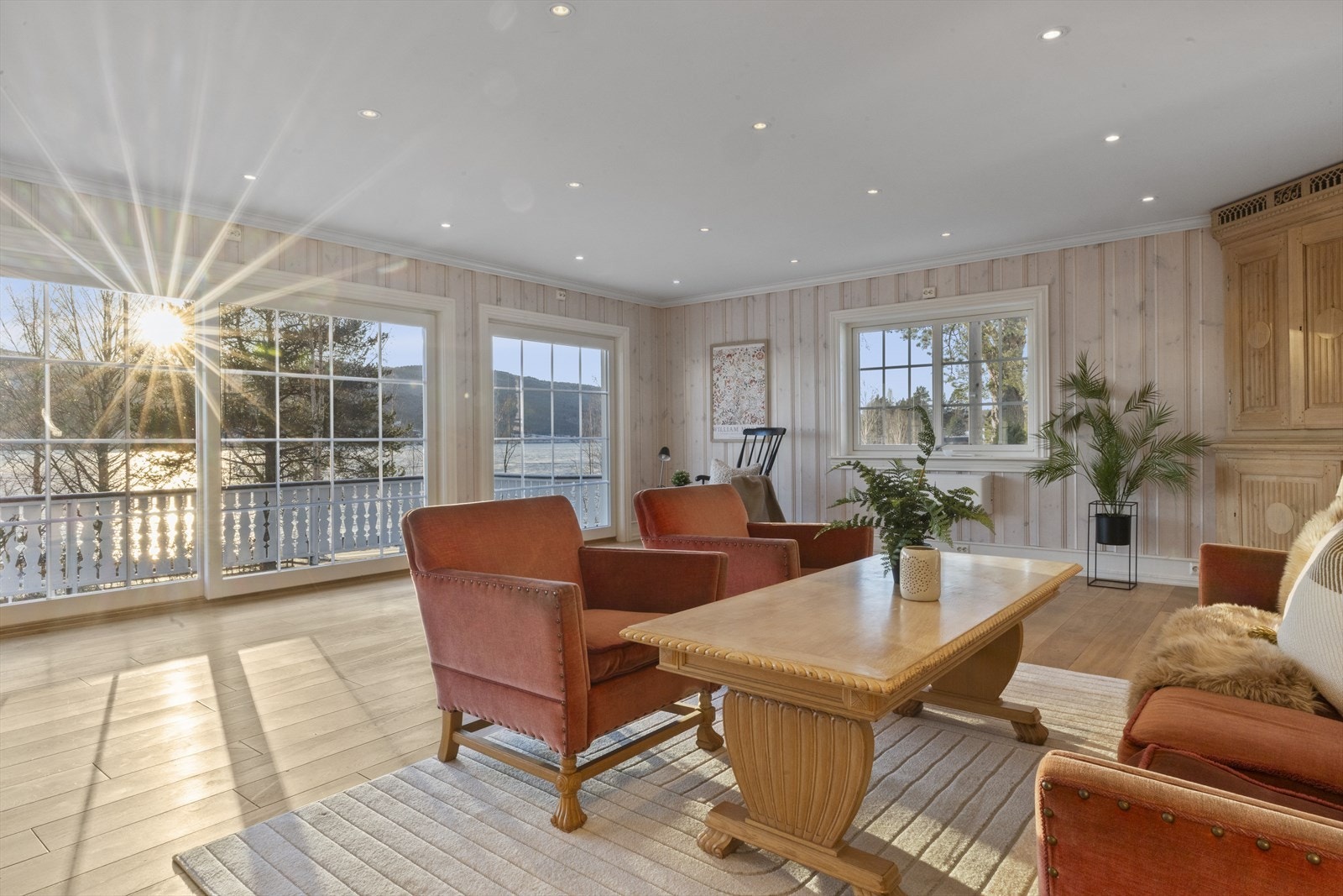 Stuens store vindusflater slipper inn rikelig med naturlig lys og rammer inn den spektakulære utsikten mot Randsfjorden Galleribilde