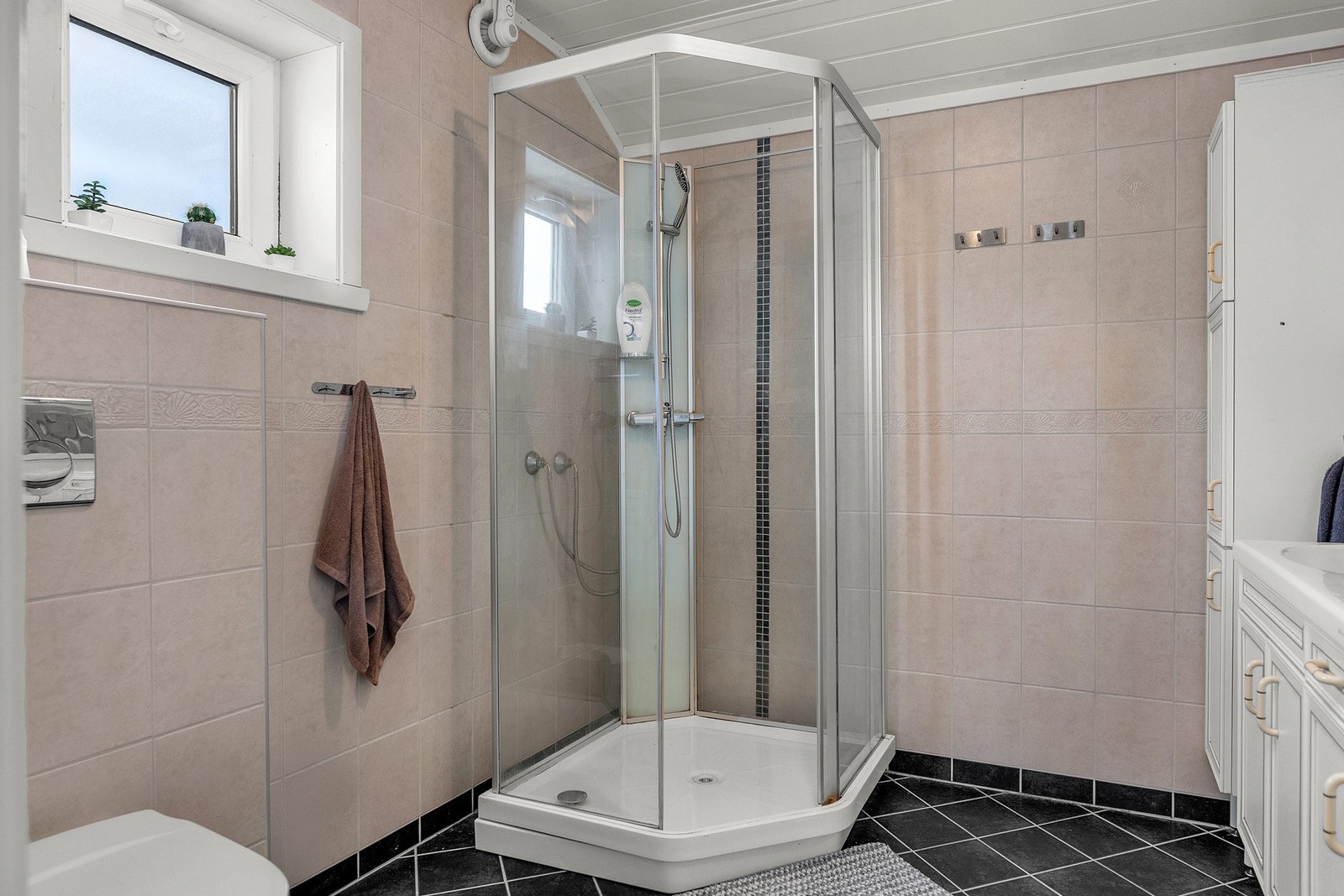 Innholdsrik baderomsinnredning med god oppbevaringsplass, vegghengt toalett og dusjkabinett Galleribilde