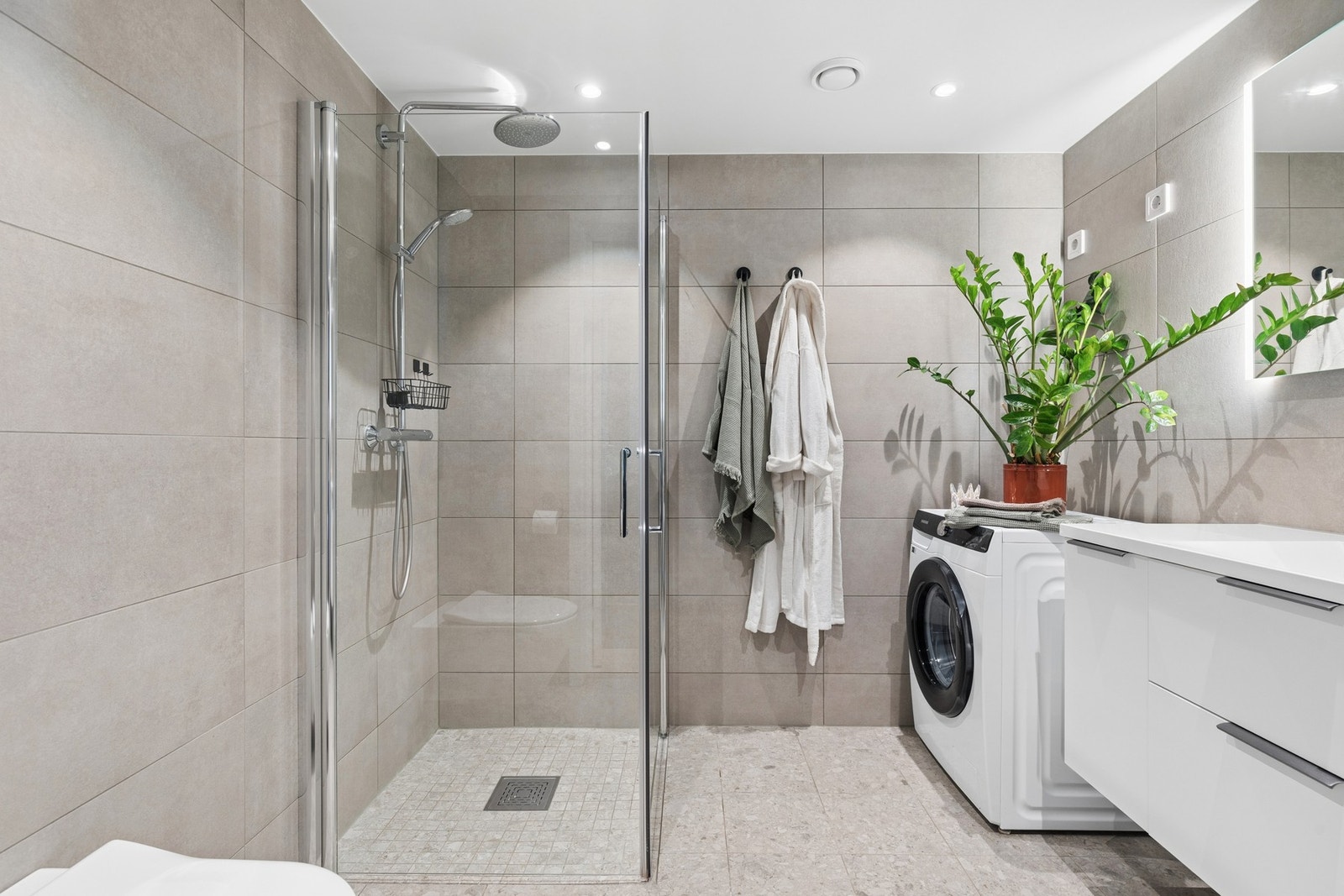 Badet er delikat og helfliset fra byggeår, med gulvvarme, vegghengt toalett, dusjhjørne med både regndusj og hånddusj. Galleribilde